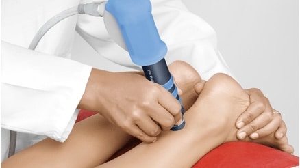 Shockwave therapy probe being applied to a patient's Achilles tendon area